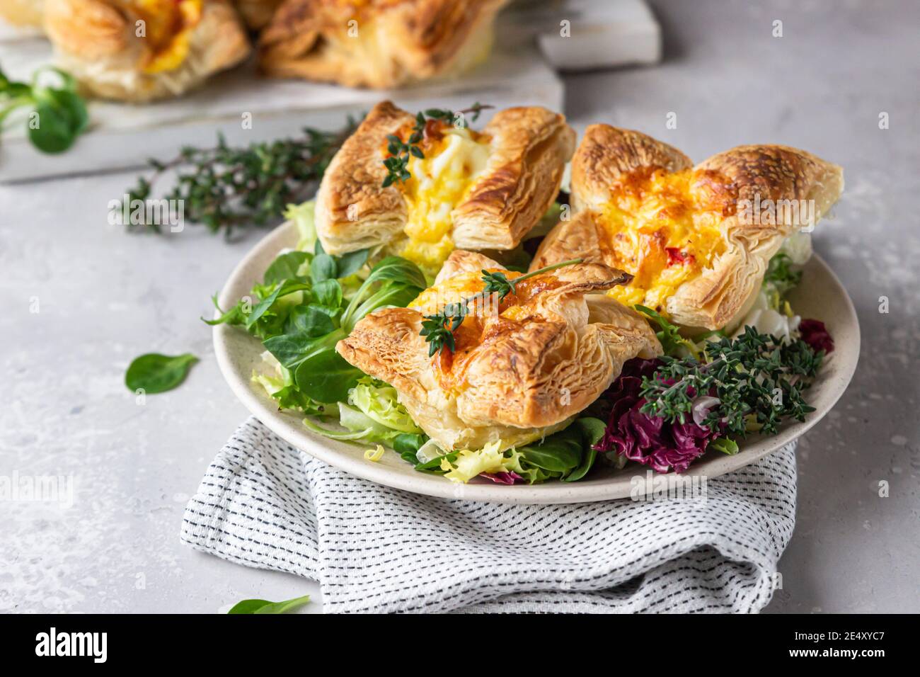 Mini quiche, tarte ou tarte avec légumes servis sur une assiette avec salade verte. Mise au point sélective. Banque D'Images