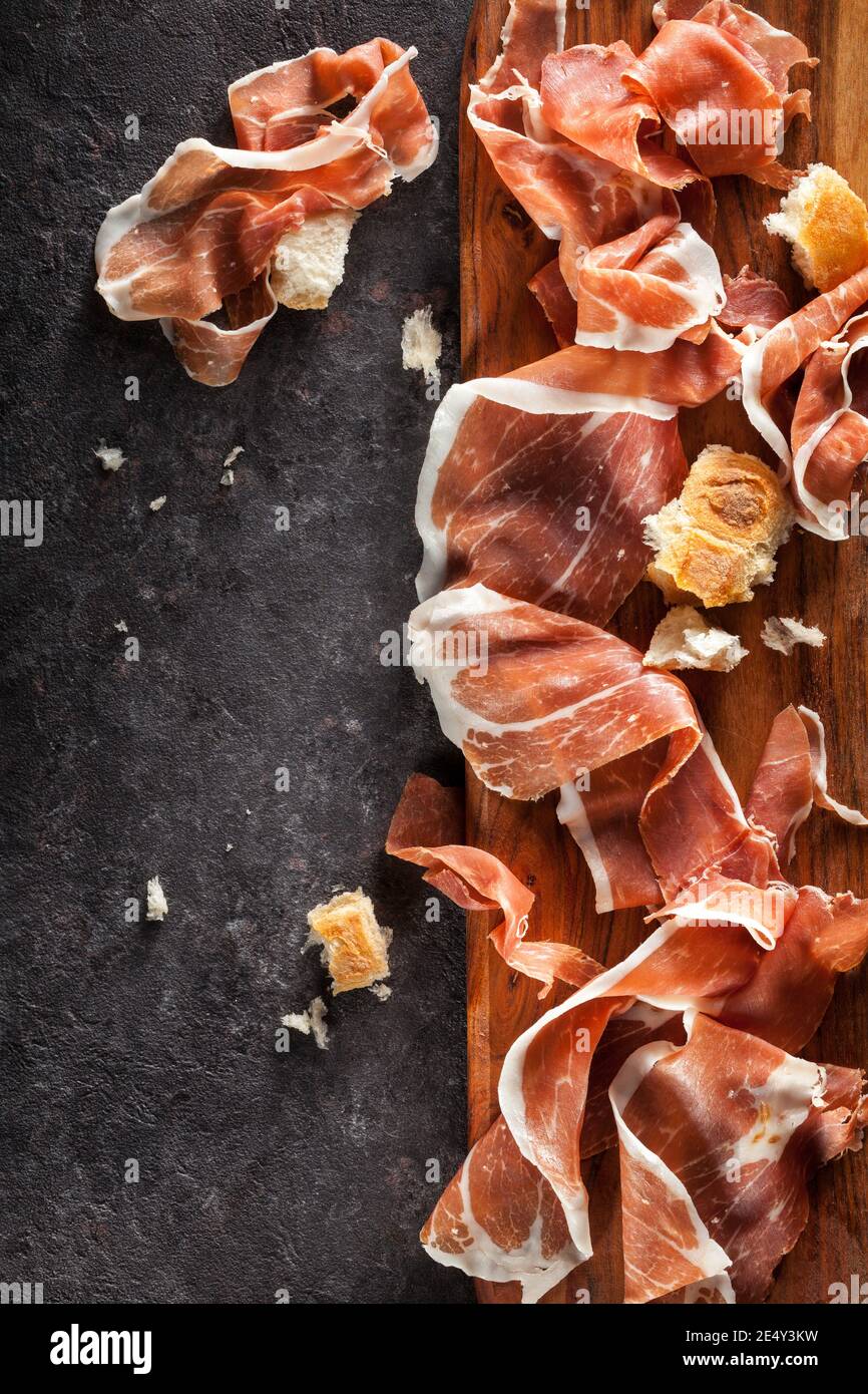 Tranches de Prosciutto sur fond sombre. Vue de dessus. Banque D'Images