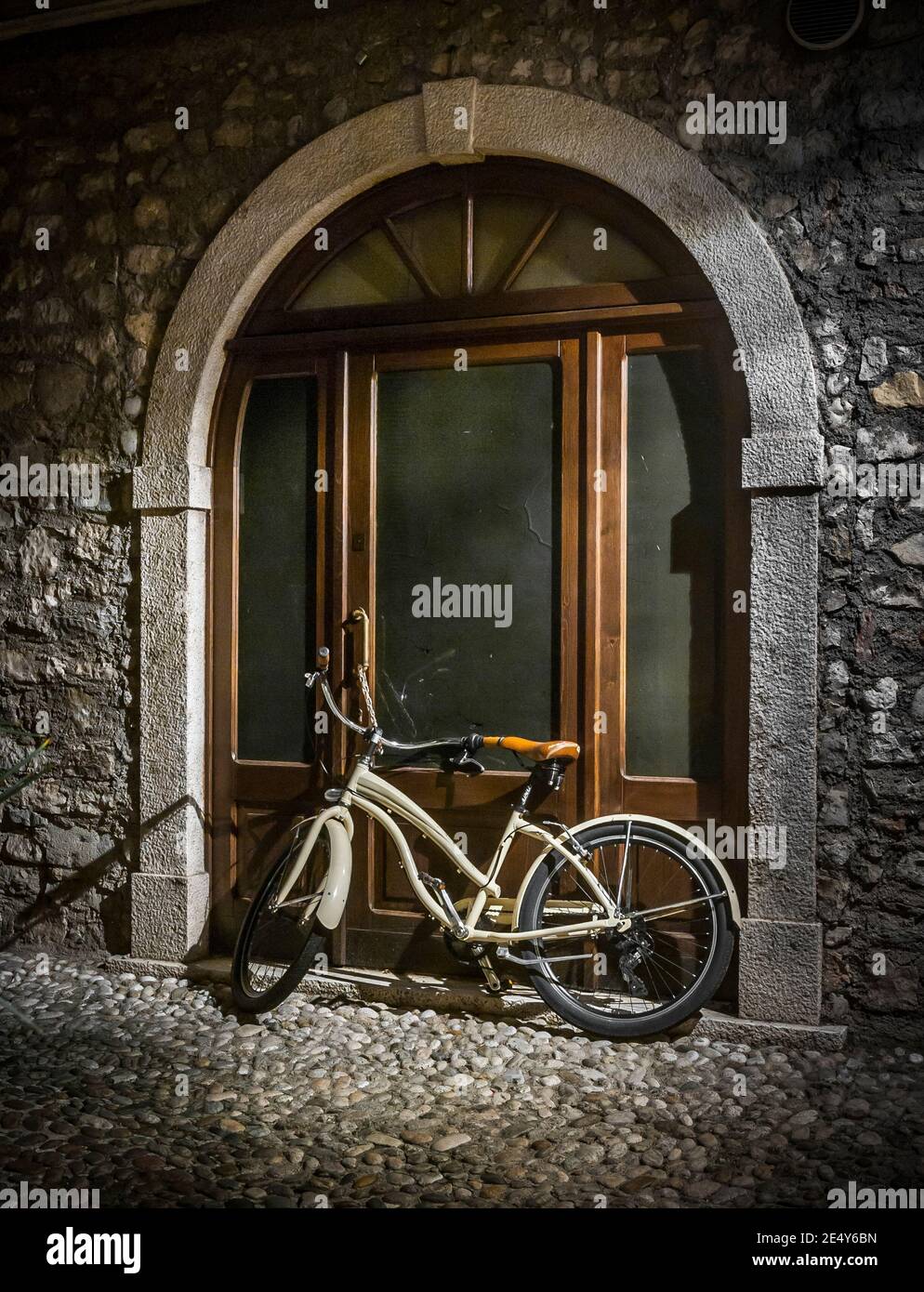 Vélo laissé à l'extérieur d'une maison sur une rue pavée à Malcesine, sur la rive est du lac de Garde dans la région de Vénétie en Italie. Banque D'Images