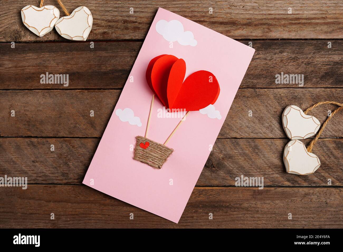 Carte De Saint Valentin Main Avec Parachute Coeur Rouge Sur Fond De Bois Photo Stock Alamy