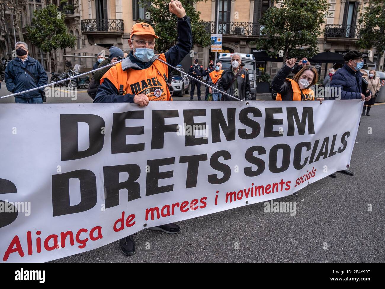 Barcelone, Espagne. 25 janvier 2021. Les manifestants portant des masques  faciaux et des gilets de marée orange des retraités affichent une bannière  pendant le rallye.la Marea Pensionista (le retraité Tide), une organisation