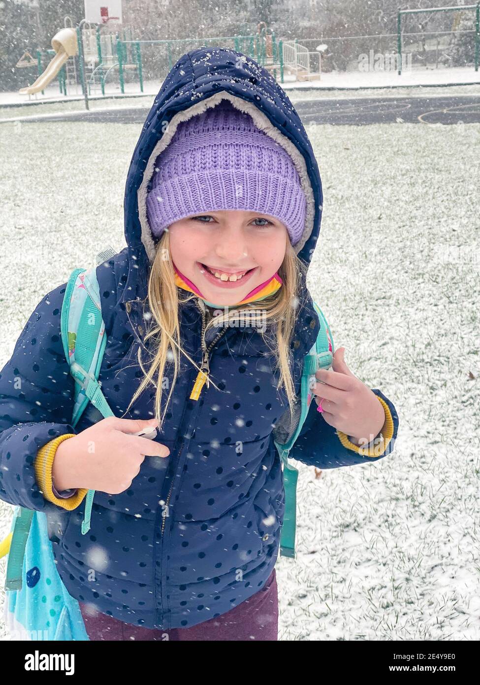 belle jeune fille d'âge scolaire jouant dans la neige Banque D'Images