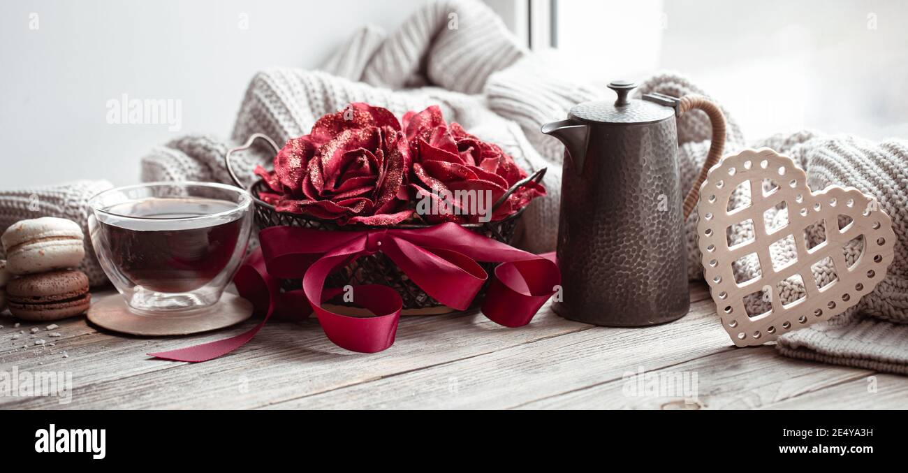 Une maison de fête encore plus vivace avec une tasse de boisson, théière, fleurs et détails de décoration. Banque D'Images
