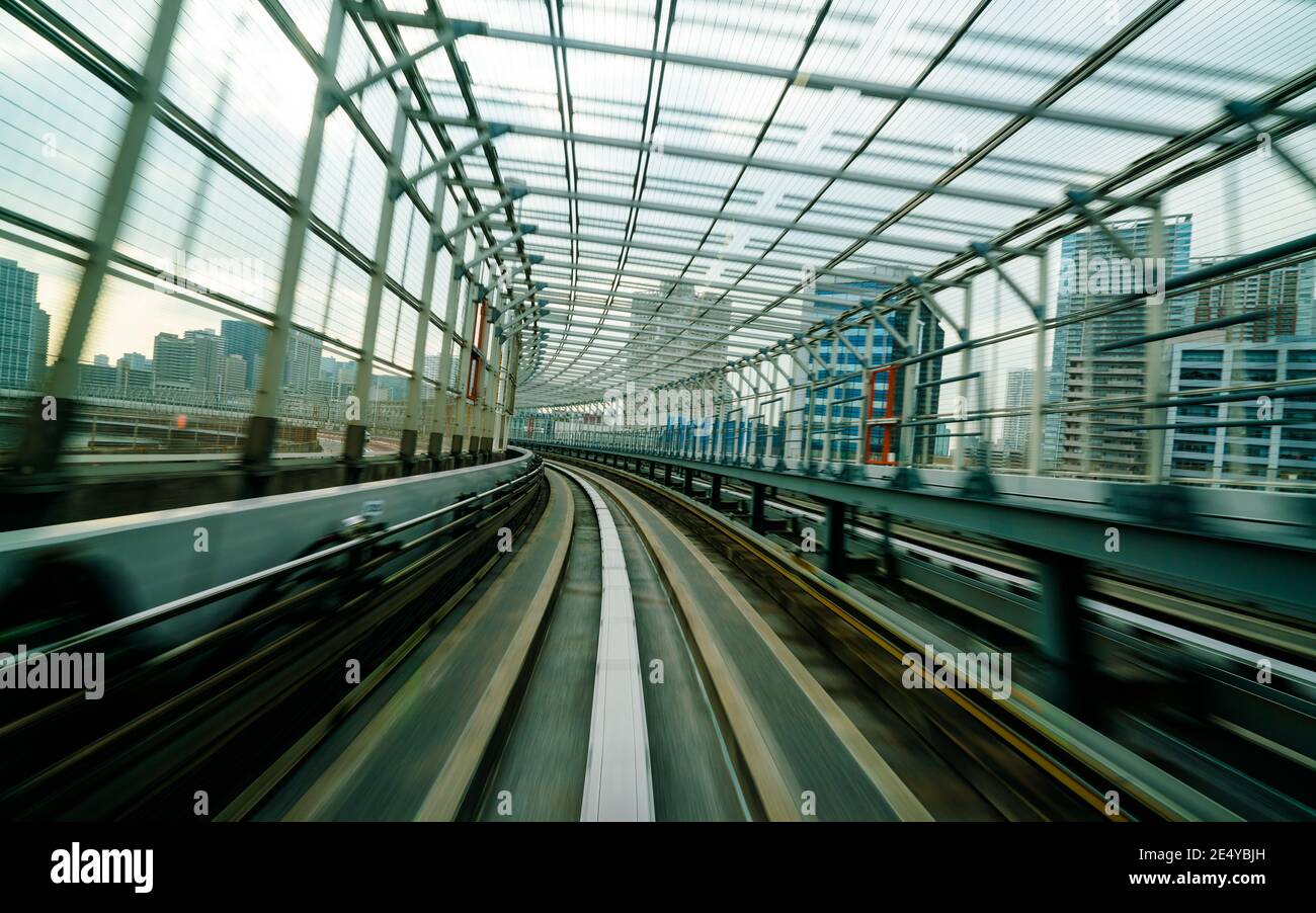 Vue de face du train en mouvement dans le tunnel ferroviaire de la ville avec un effet de flou modéré et un filtre vintage. Concept de transport et arrière-plan flou de mouvement Banque D'Images