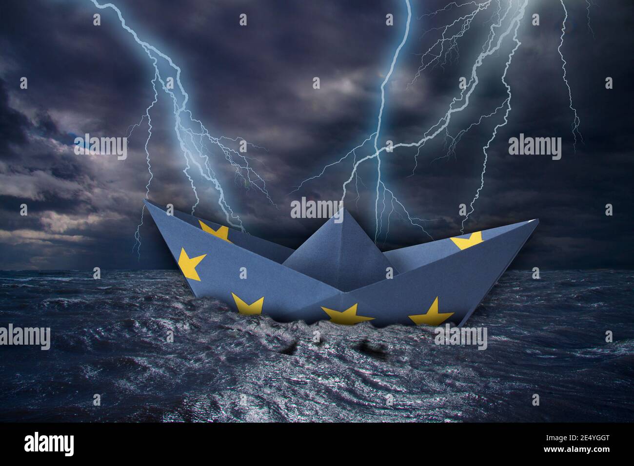 Bateau en papier de l'UE fait comme le drapeau de l'européen Union presque des catailles dans les hautes vagues et boulon de foudre au-dessus de la mer sombre orageux pendant une tempête de tonnerre w Banque D'Images