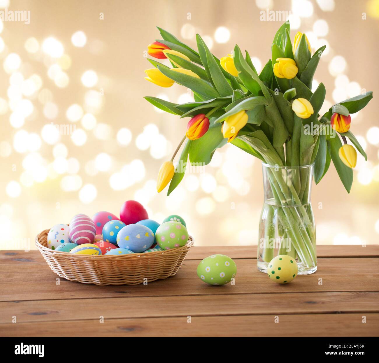 Œufs de Pâques colorés dans panier et fleurs tulipes Banque D'Images