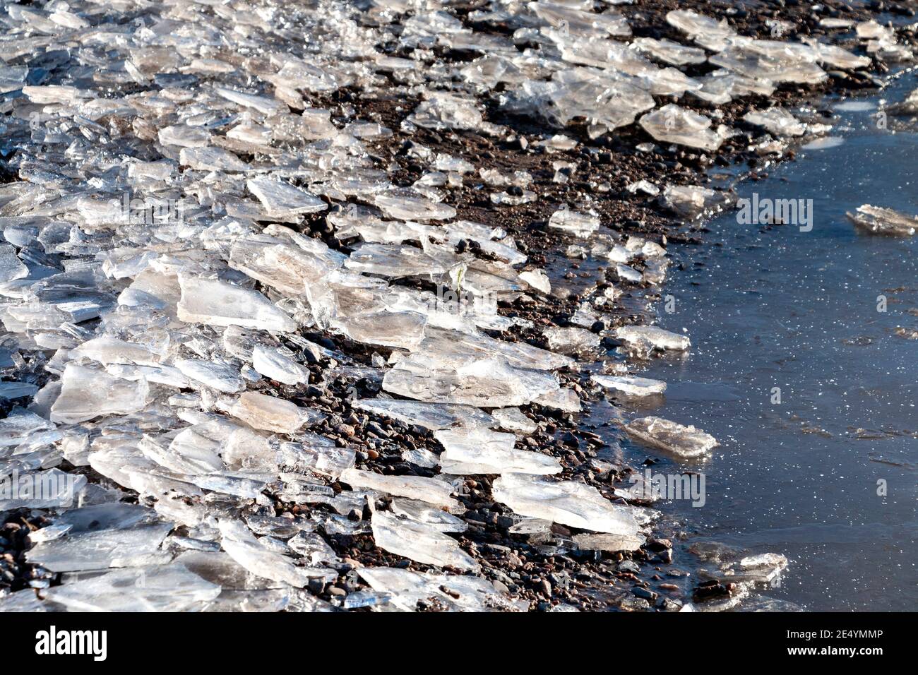 DES MORCEAUX OU DES BANDES DE GLACE D'HIVER AUTOUR D'UN NID DE POULE UNE ROUTE Banque D'Images