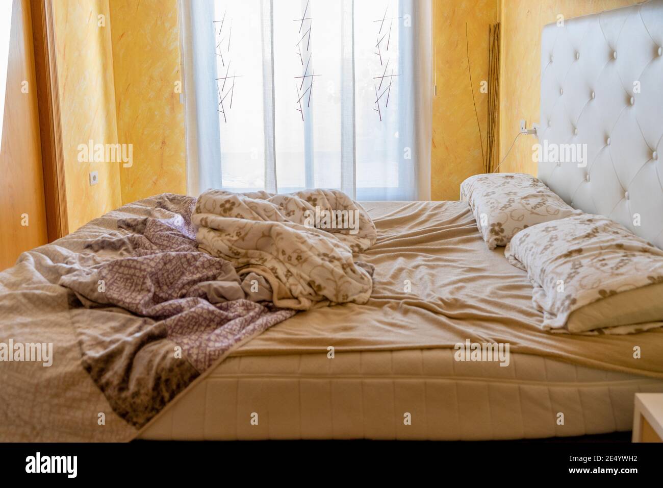 Vue sur la chambre double dans laquelle se trouve le lit non fabriqué. Mise au point sélective. Concept de maison Banque D'Images