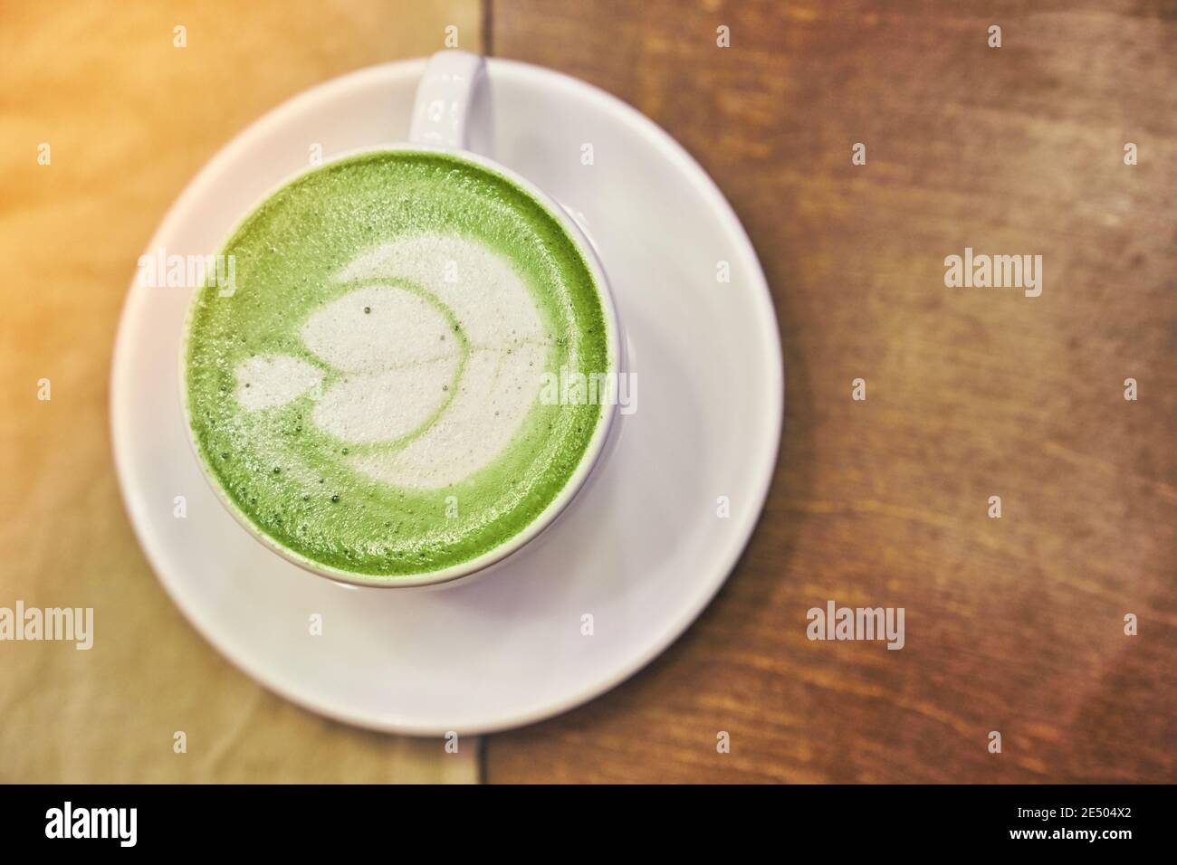 Tasse de matcha latte sur fond de bois et une serviette beige dans un café avec espace de copie. Photo de haute qualité Banque D'Images