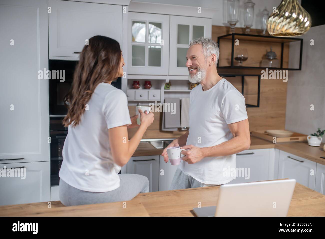 Couple prenant le café du matin dans leur cuisine Banque D'Images