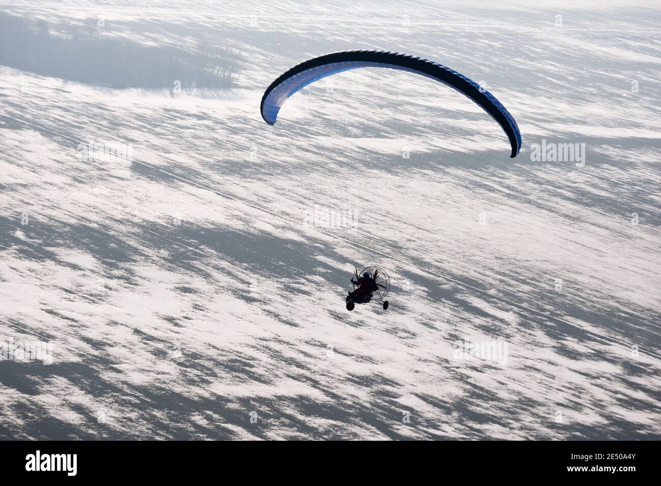 Vue aérienne du buggy à paramoteurs ou parapente motorisée vue depuis le Ciel en France et vol sur des champs enneigés en hiver Banque D'Images