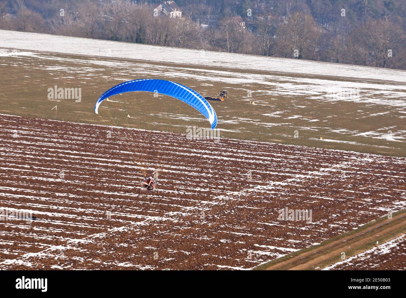 Parapente motorisé ou paramoteur se préparant à atterrir sur une lumière Piste d'avion pour ULM en hiver sous la neige Banque D'Images