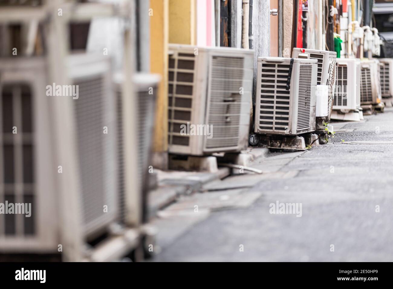 Vue rapprochée d'une rangée d'unités externes de climatisation, bordées dans une allée arrière Banque D'Images