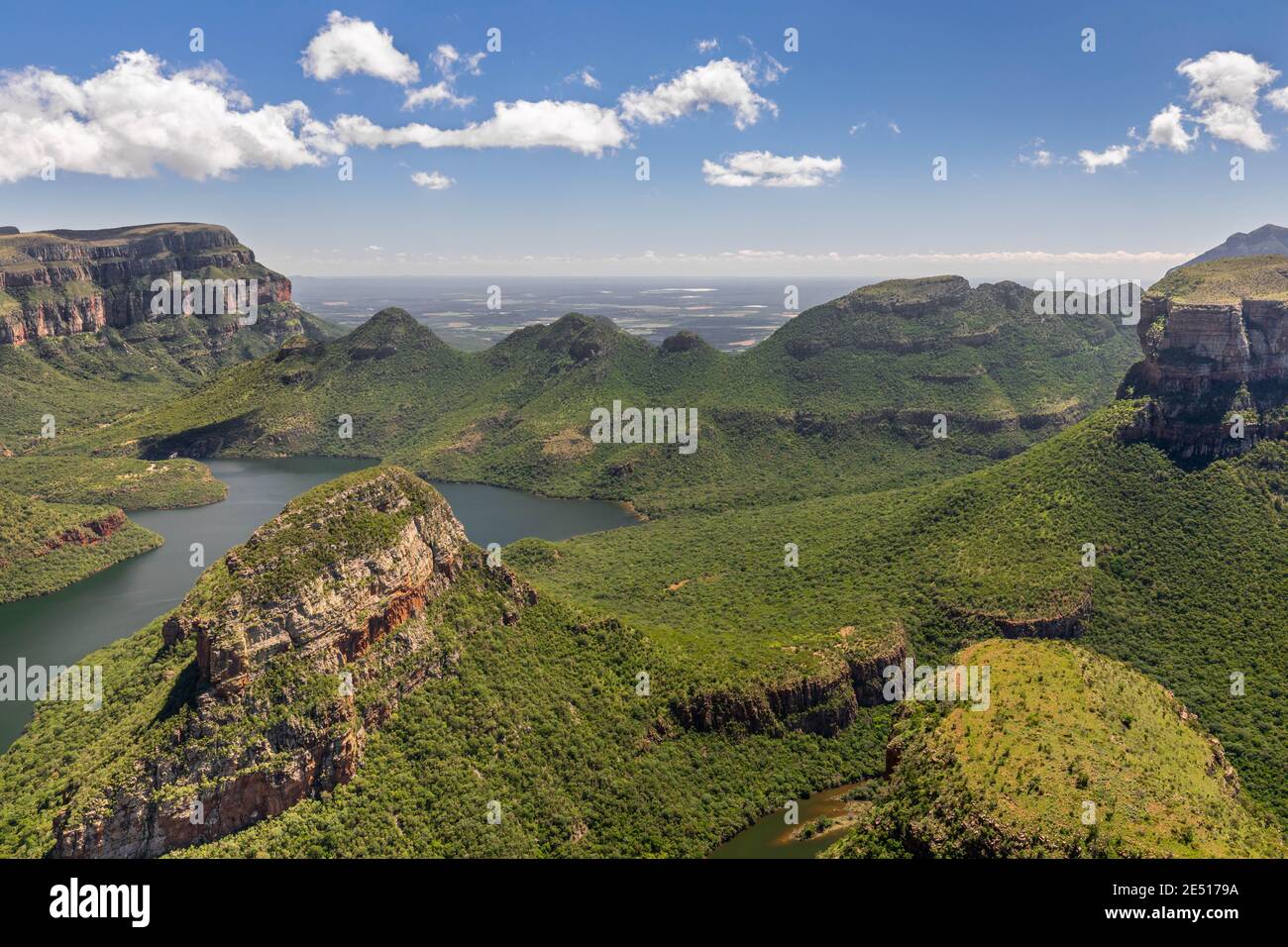 Prise de vue en grand angle du Blyde River Canyon couvert par végétation verte luxuriante sous un ciel bleu avec des nuages Banque D'Images