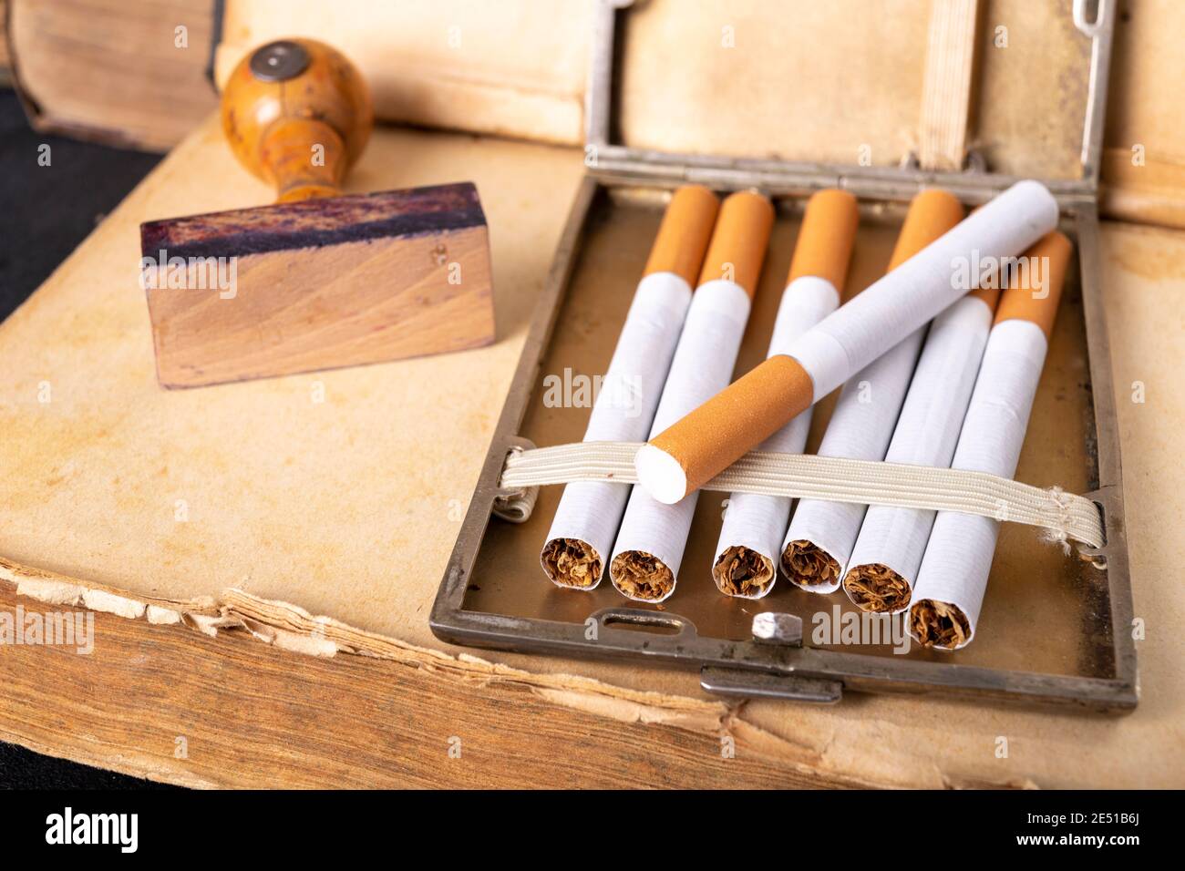 Timbre en bois pour l'estampage et les cigarettes dans une bote   cigarettes en mtal. Accessoires de bureau dans l'ancien bureau.  Arrire-plan sombre Photo Stock - Alamy