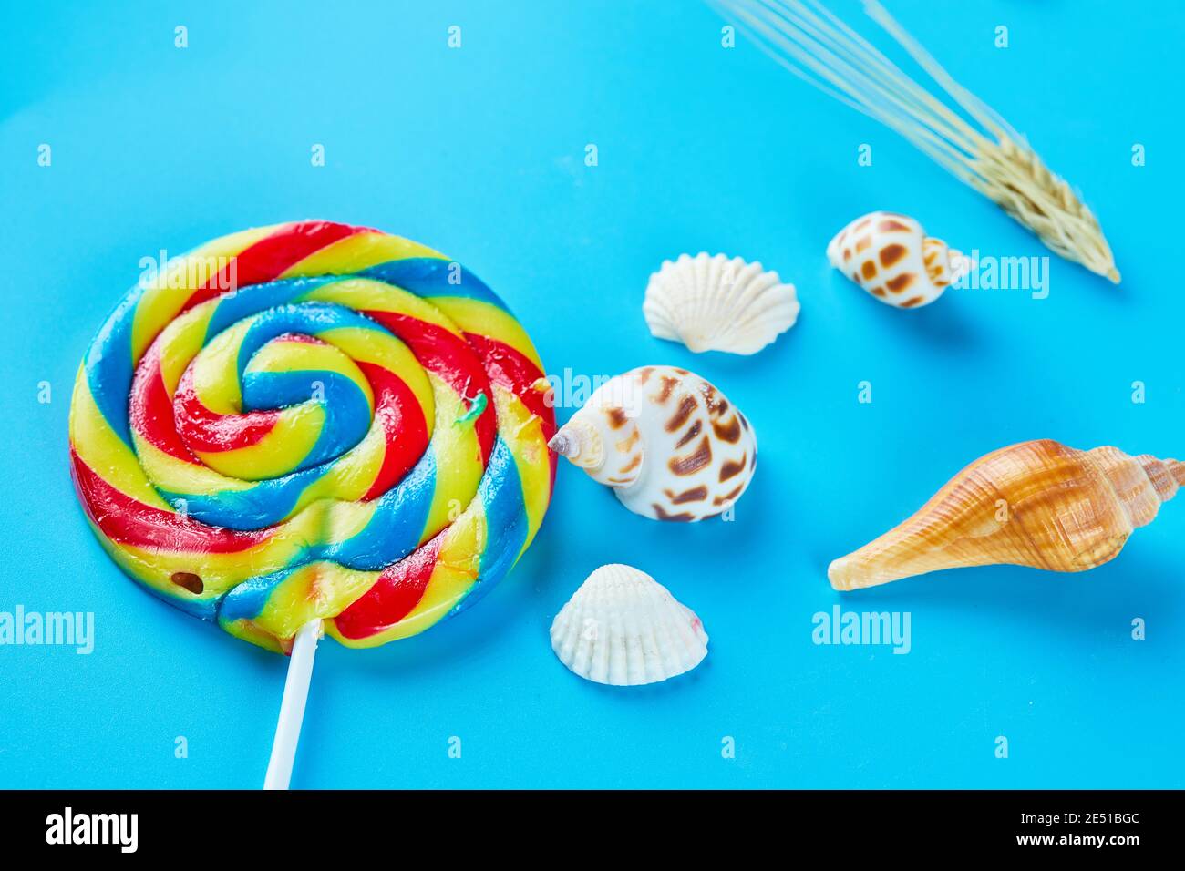 Sucettes colorées avec coquillages sur fond bleu Banque D'Images