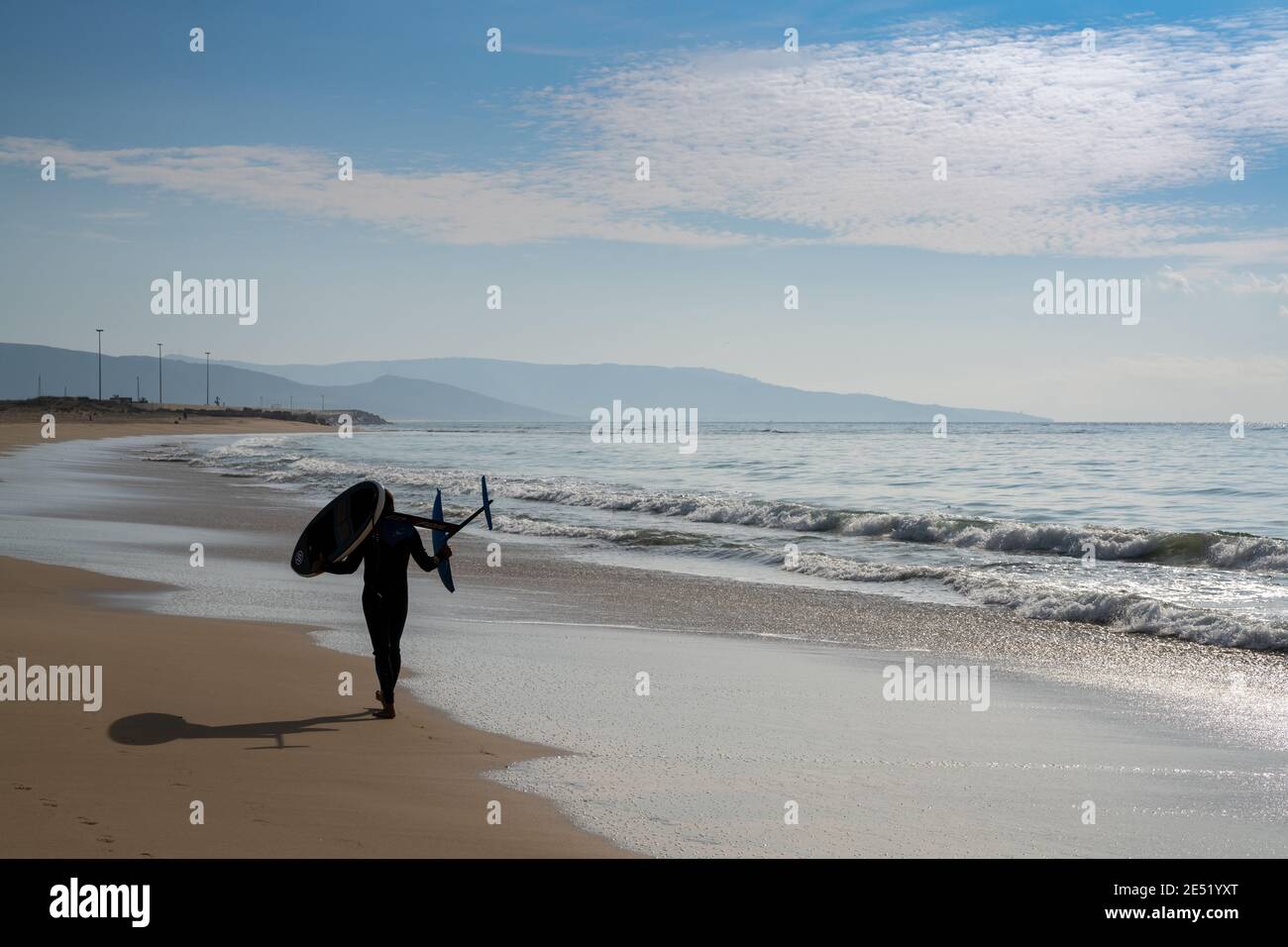 Barbate, Espagne - 19 janvier 2021 : surfeur marchant le long d'une plage avec une planche de surf hydrofoil Banque D'Images
