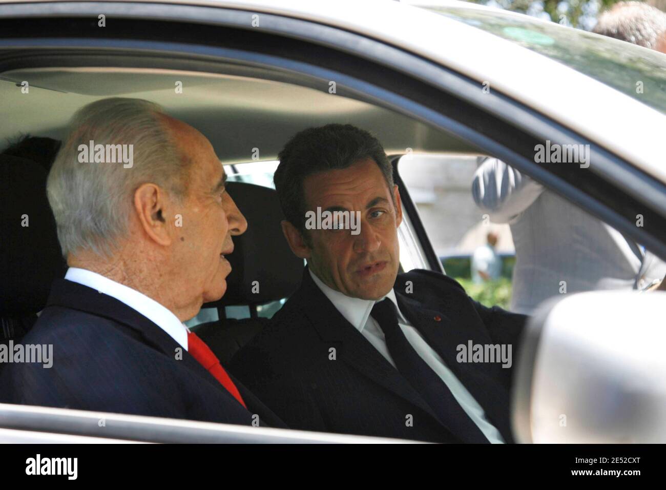 Le président français Nicolas Sarkozy (C) et son homologue israélien Shimon  Peres (L) s'assoient dans une voiture électrique Renault Megane lors de la  présentation du véhicule près de l'hôtel King David à