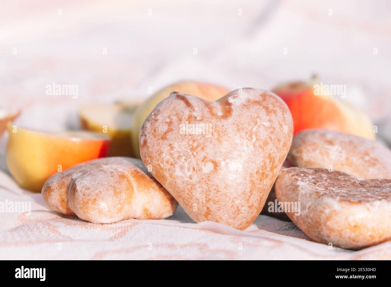 Biscuits glacés au pain d'épice en forme de coeur. Pique-nique dans la nature, en-cas léger avec pommes et biscuits.produits de la Saint-Valentin. Mise au point sélective Banque D'Images