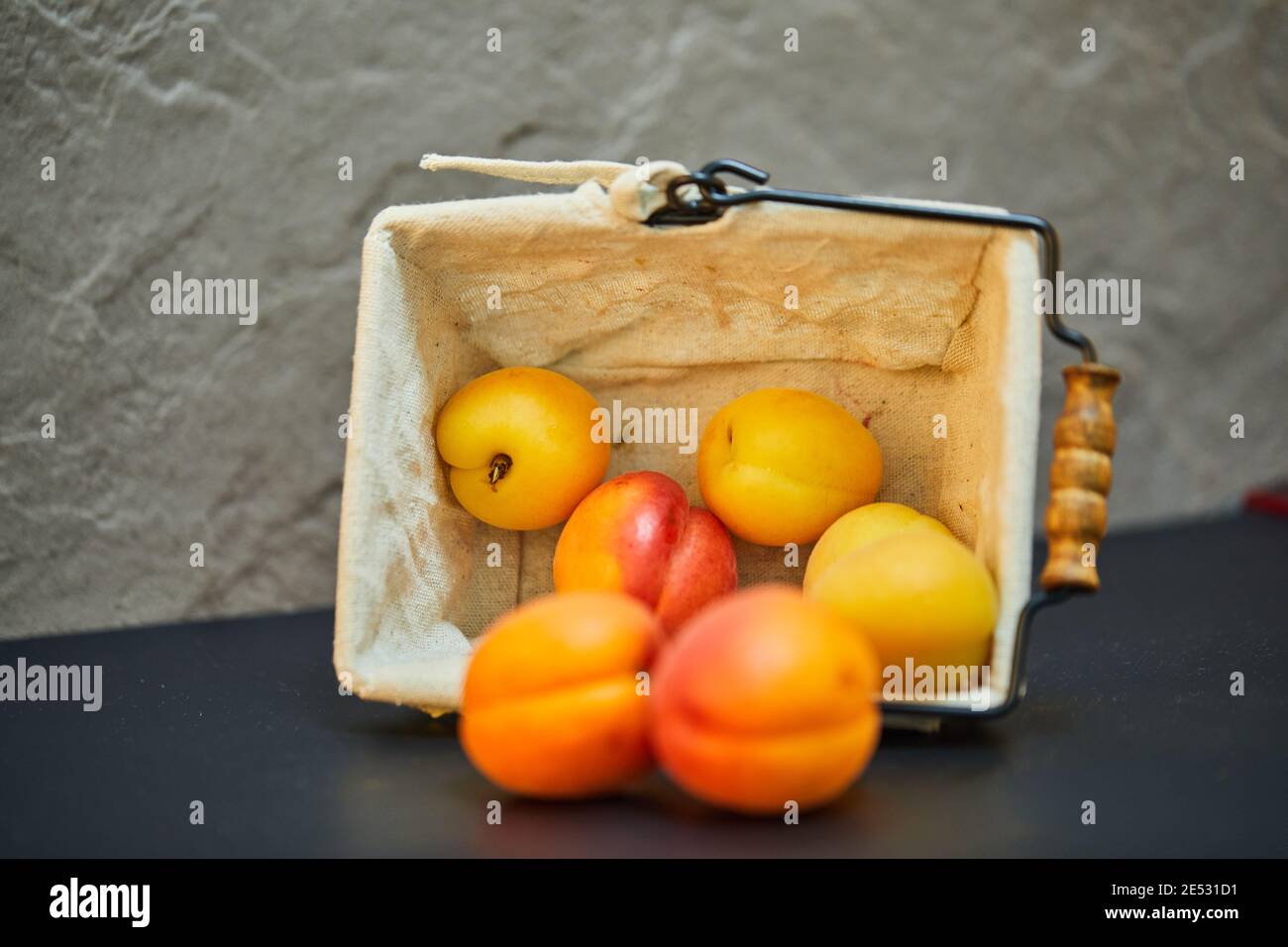 Nectarines et abricots en panier sur fond bleu Banque D'Images