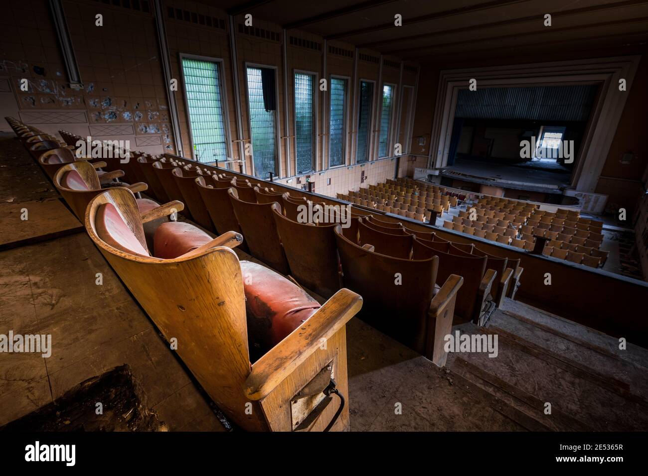 Prise de vue grand angle de l'intérieur d'un cinéma ancien et abandonné, avec les rangées arrière en premier plan et l'écran en arrière-plan Banque D'Images