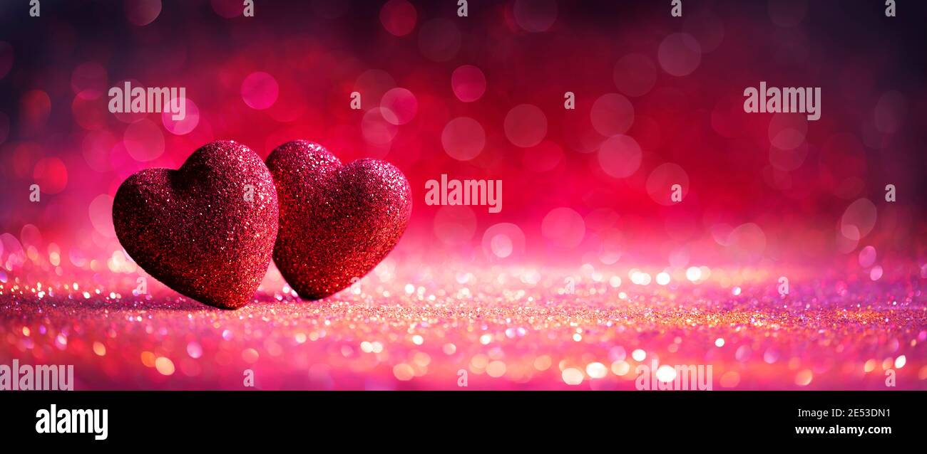 Carte abstraite de Saint-Valentin défochée avec cœur rouge sur paillettes brillantes Banque D'Images