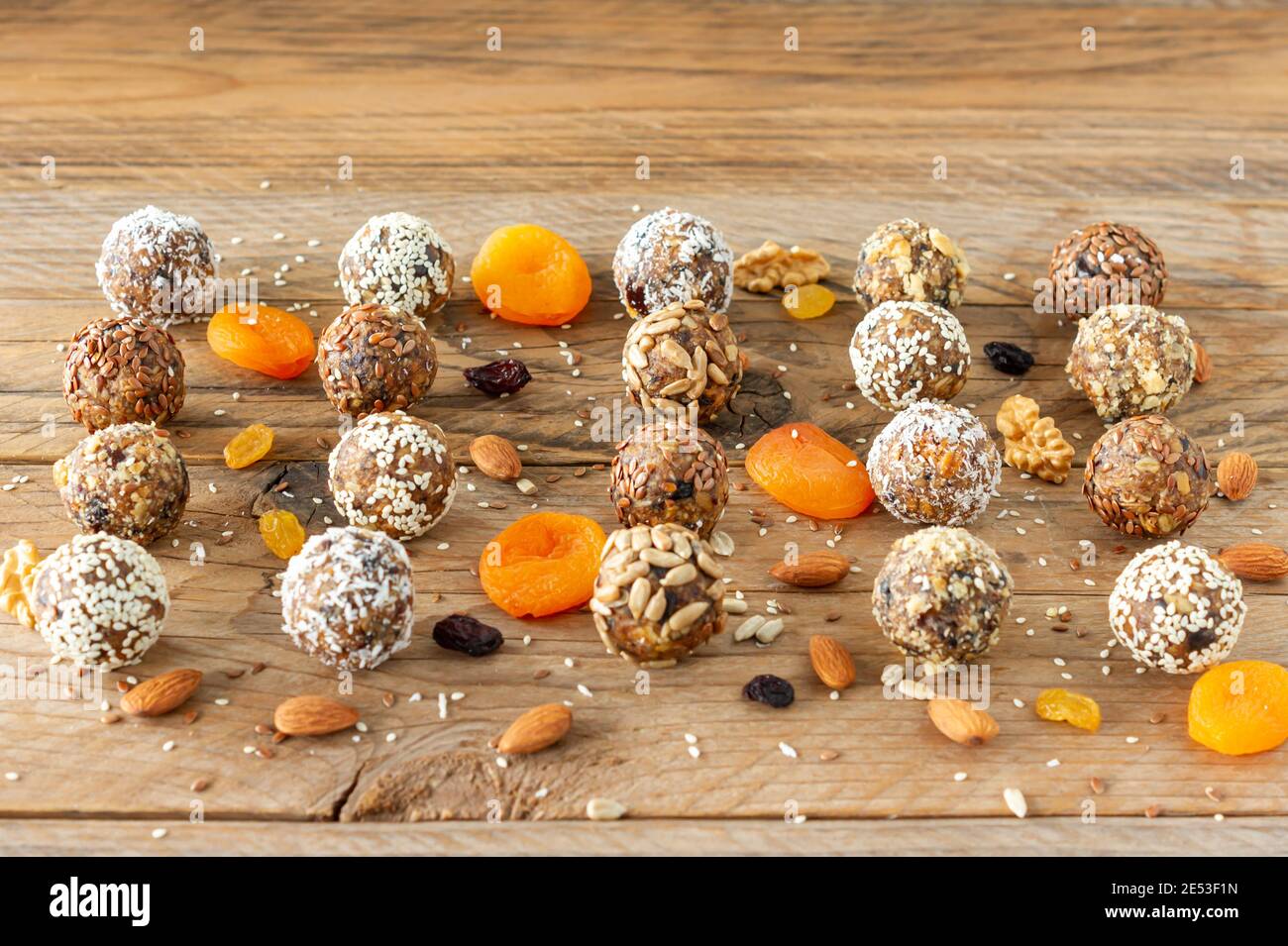 Boules de protéines d'énergie avec des ingrédients sains sur table en bois. Maison faite avec des dattes, amande, lin et graines Banque D'Images