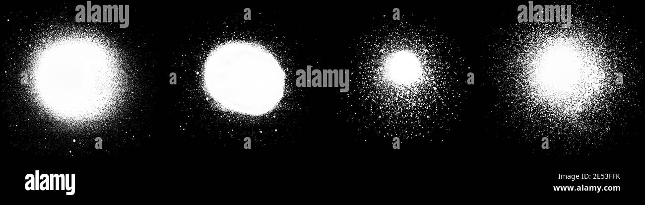 Gros plan de plusieurs taches et éclaboussures de peinture en aérosol blanc, isolées sur fond noir. Banque D'Images