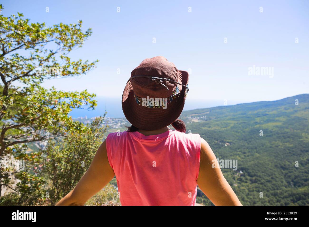 Femme dans un chapeau regarde la vue panoramique de la montagne à la mer et  la forêt. Tourisme, trekking, voyage. Écotourisme actif, vie saine Photo  Stock - Alamy