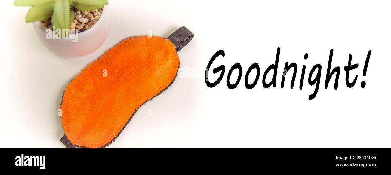 Vue de dessus d'un masque de sommeil orange et d'une fleur, une attitude positive au sommeil, une bannière avec le texte Bonne nuit. Banque D'Images