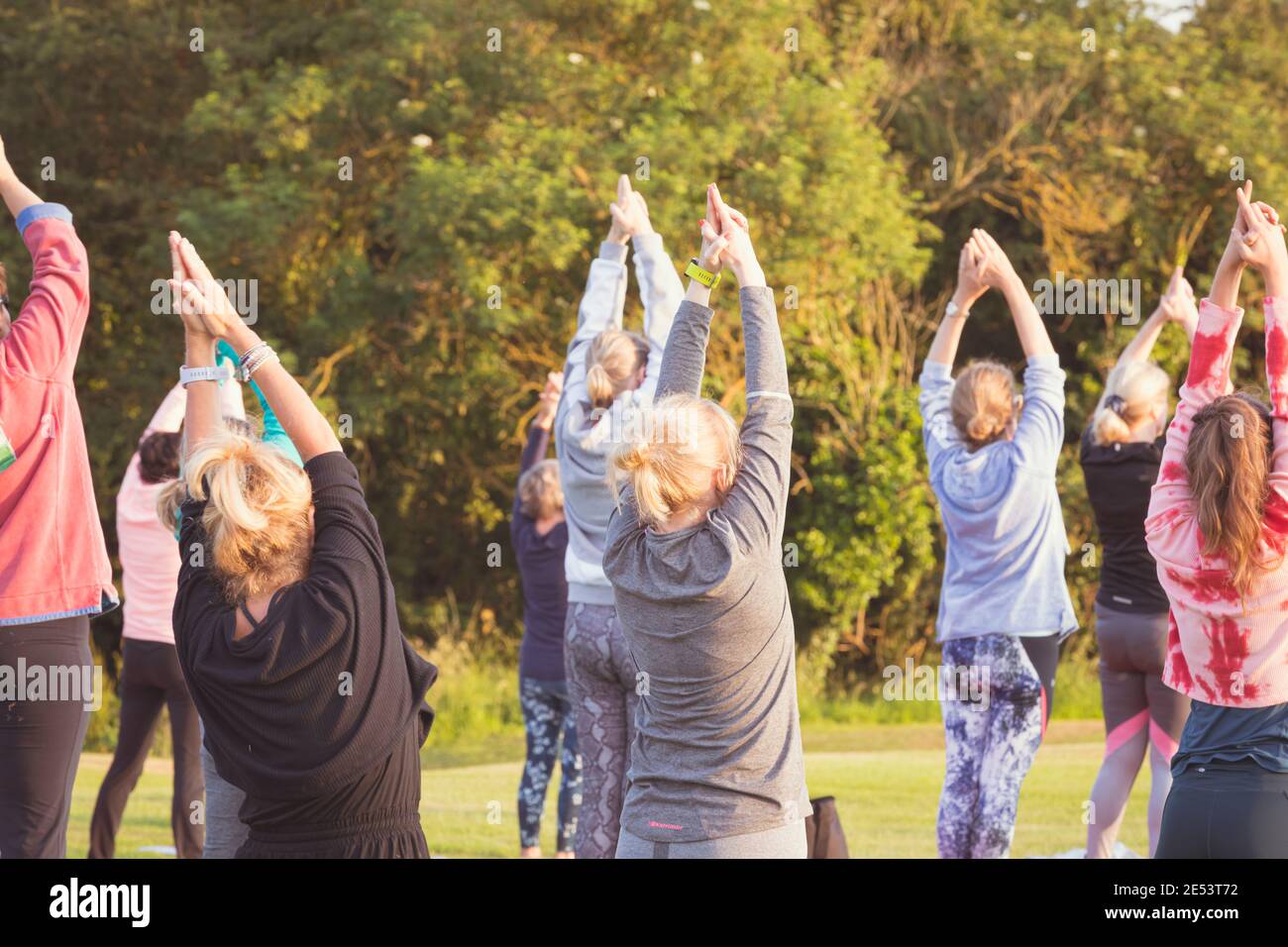 Cours de yoga en plein air au coucher du soleil dans un cadre naturel Banque D'Images