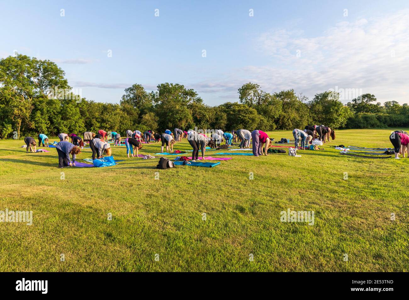 Cours de yoga en plein air au coucher du soleil dans un cadre naturel Banque D'Images