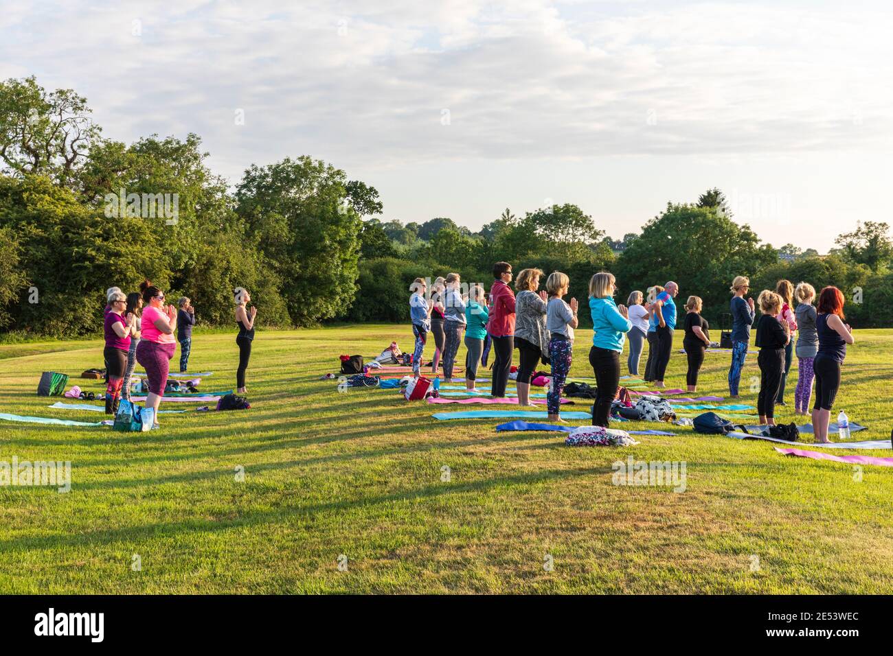 Cours de yoga en plein air au coucher du soleil dans un cadre naturel Banque D'Images