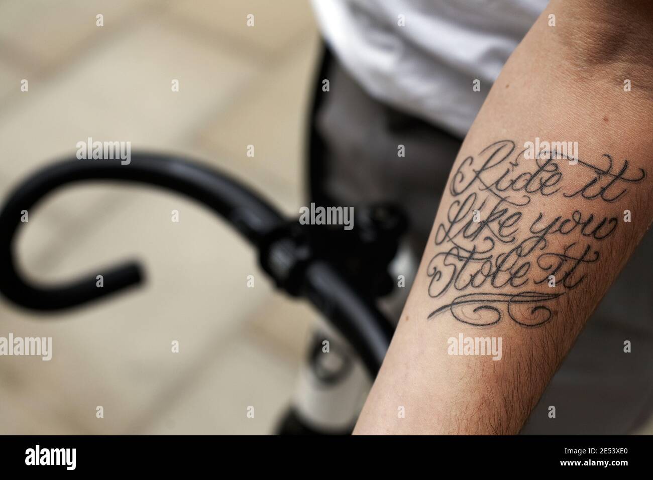 gros plan de cycliste avec tatouage sur son bras Ride il comme vous l'avez volé avec guidon . Banque D'Images