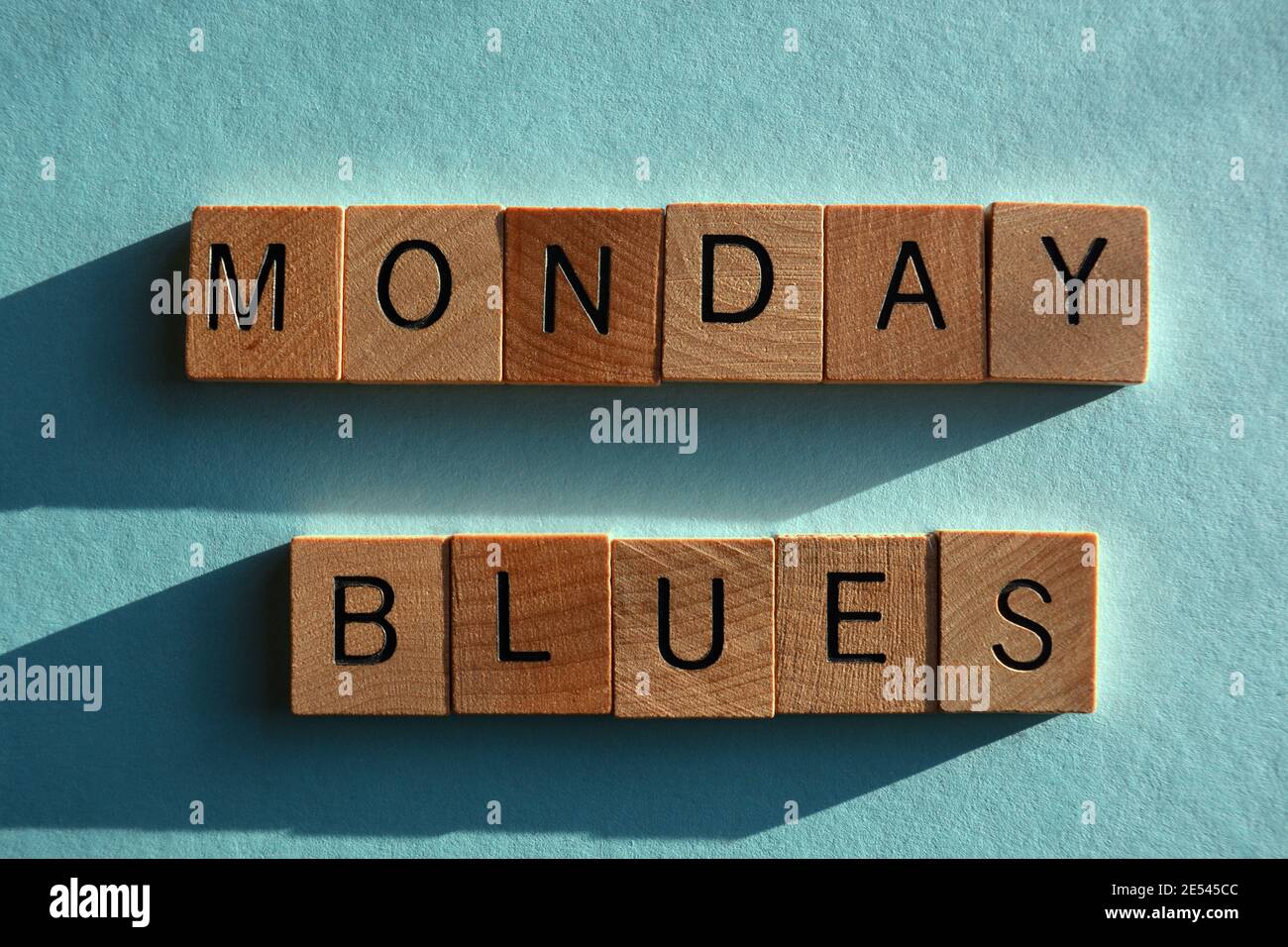 Monday Blues, mots en lettres de l'alphabet en bois isolés sur fond bleu pâle Banque D'Images