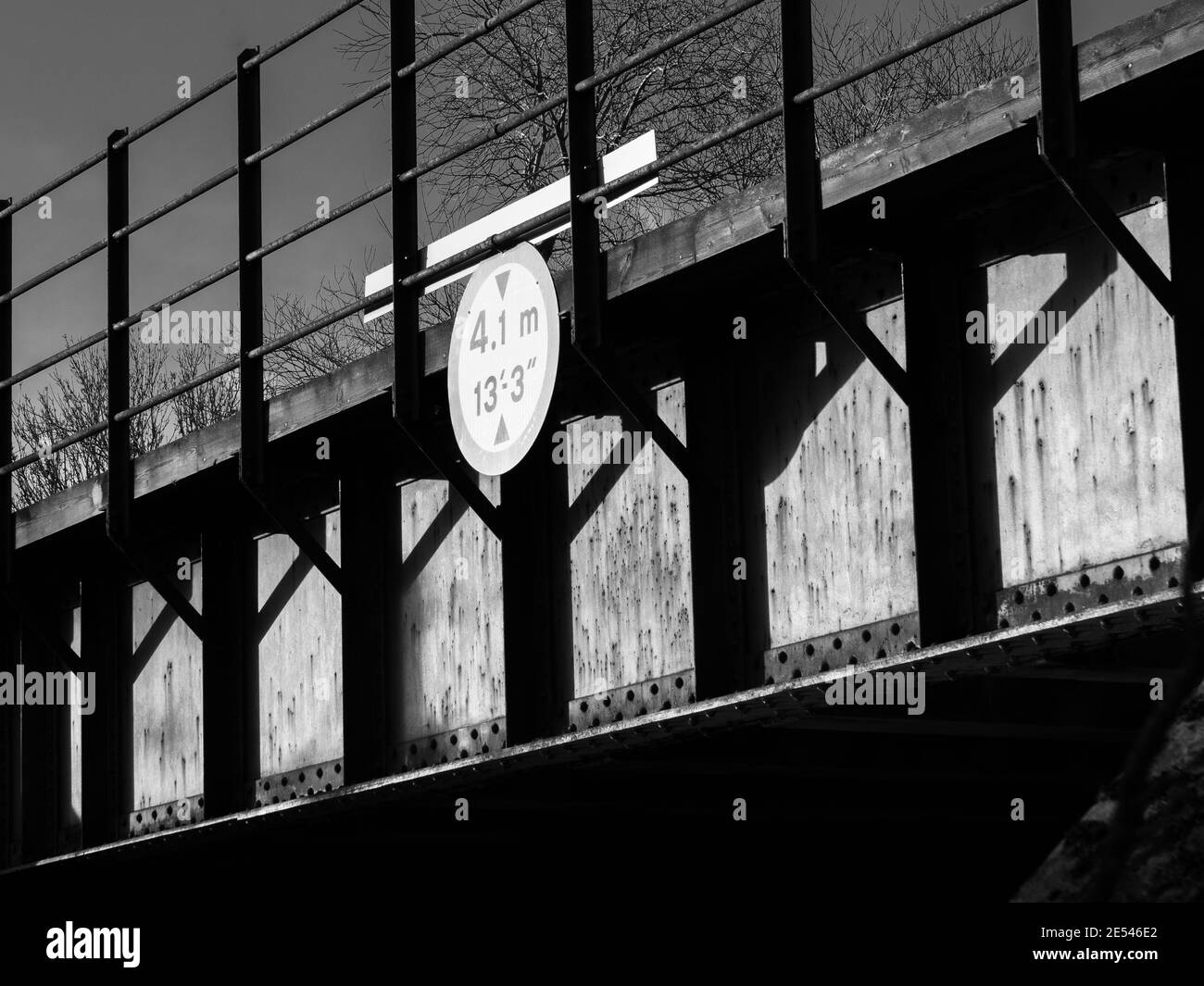 Image monochrome d'un pont ferroviaire plein de lignes, d'angles et d'ombres. Banque D'Images