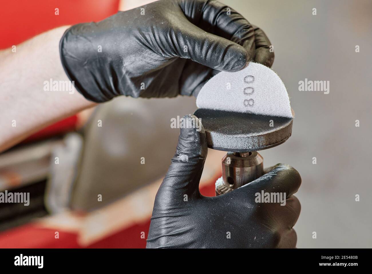 mains humaines gantées placer du papier de verre sur un polisseur. disques abrasifs. outils de polissage et concept de travail Banque D'Images