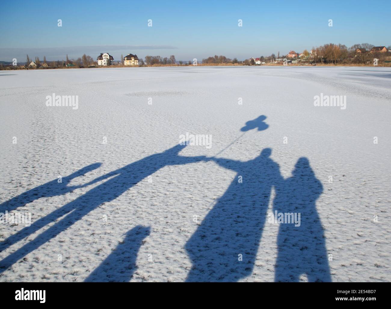 Ombres dans la neige d'une famille sympathique et méconnaissable. Quatre mains libres. Parents, enfants et chien. Mode de vie actif, marche. Hiver ensoleillé jour Banque D'Images