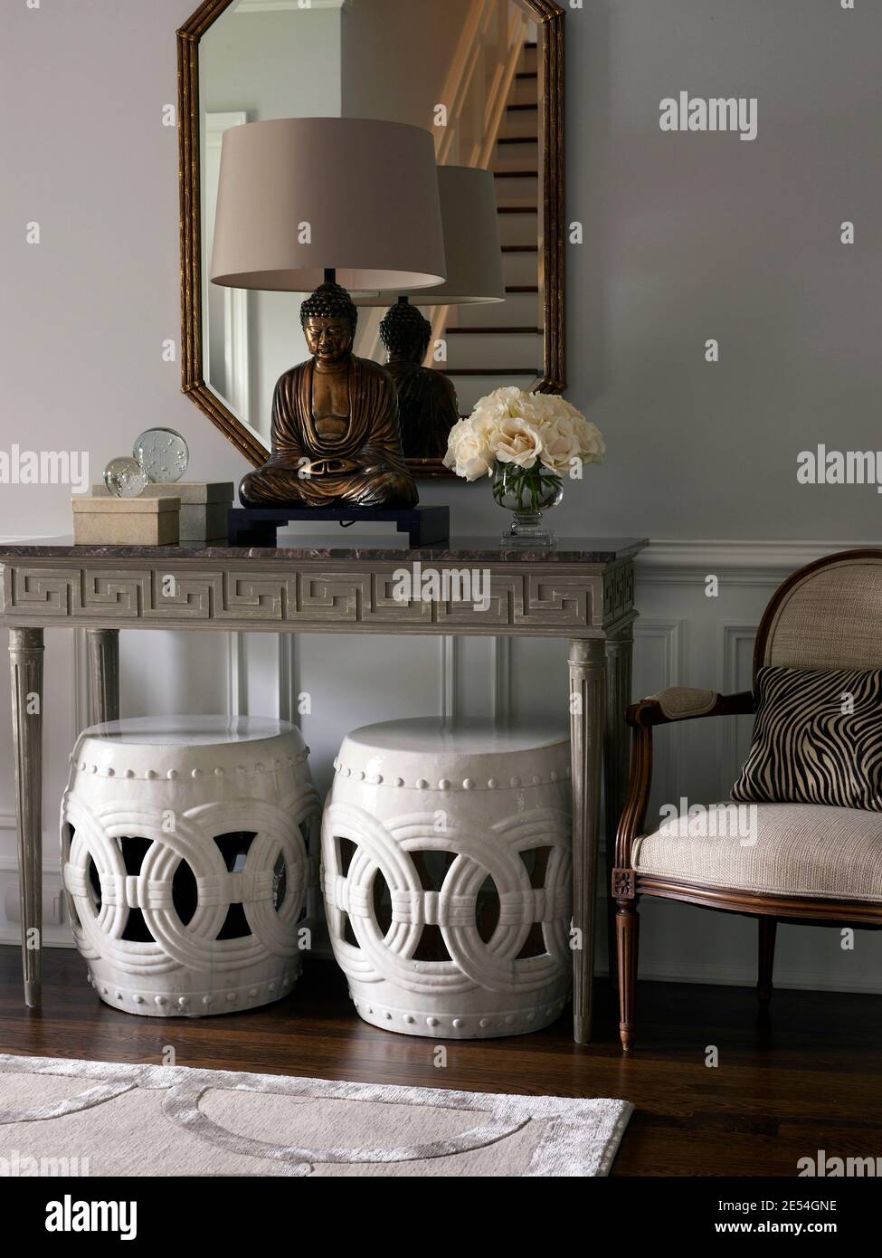 Statue de Bouddha sur la table de console avec tabourets dans le couloir de la maison de ville de transition contemporaine, Stamford, Fairfield County, Connecticut, États-Unis Banque D'Images