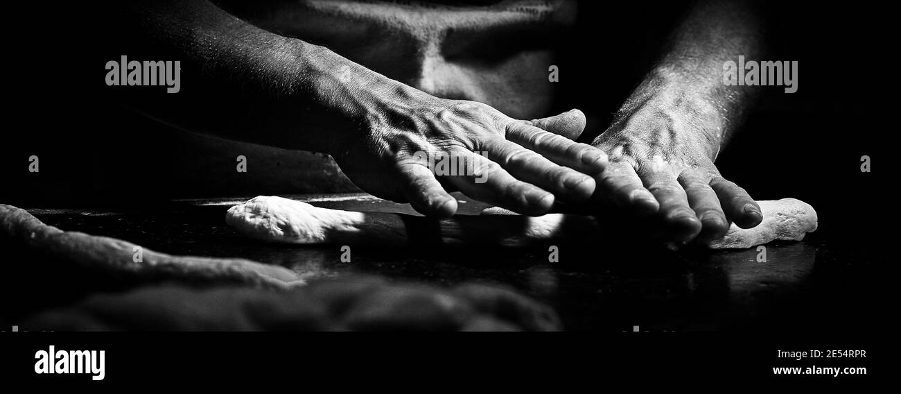 Mains d'un boulanger qui pétrit et prépare la pâte pour le pain Banque D'Images