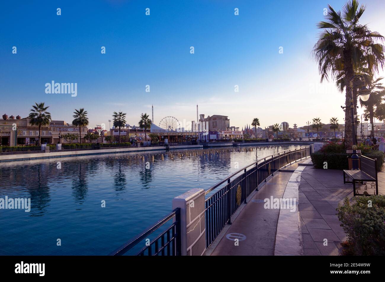 Belle vue sur les pavillons, et Canal avec bateaux de plaisance dans le centre de divertissement du parc capturé au coucher du soleil à Global Village, Dubaï Banque D'Images