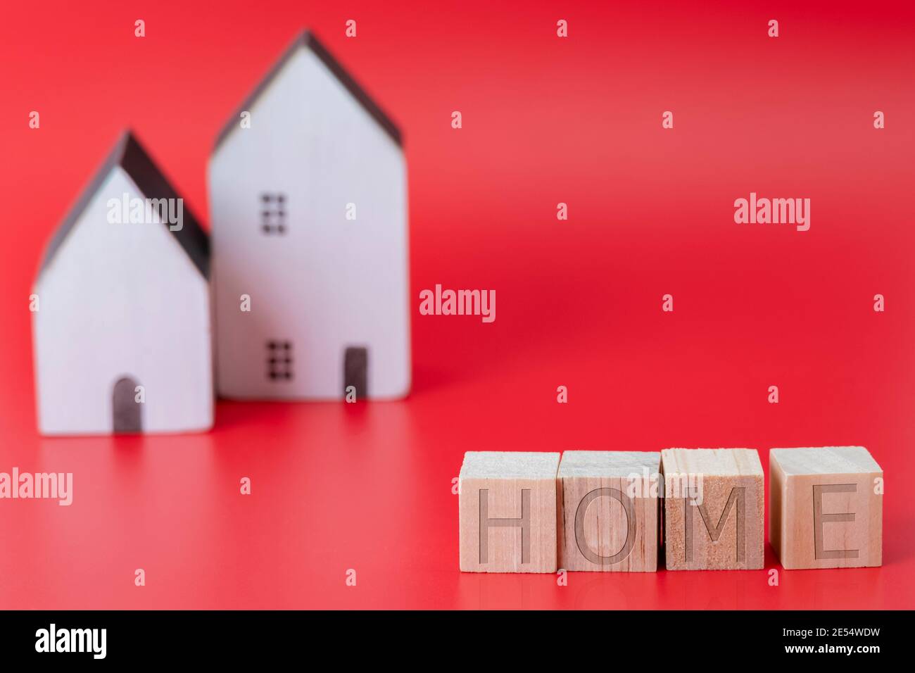 Gros plan d'un bloc de texte maison en bois avec modèle de maison miniature sur fond bleu symbole du nouveau concept de maison Banque D'Images