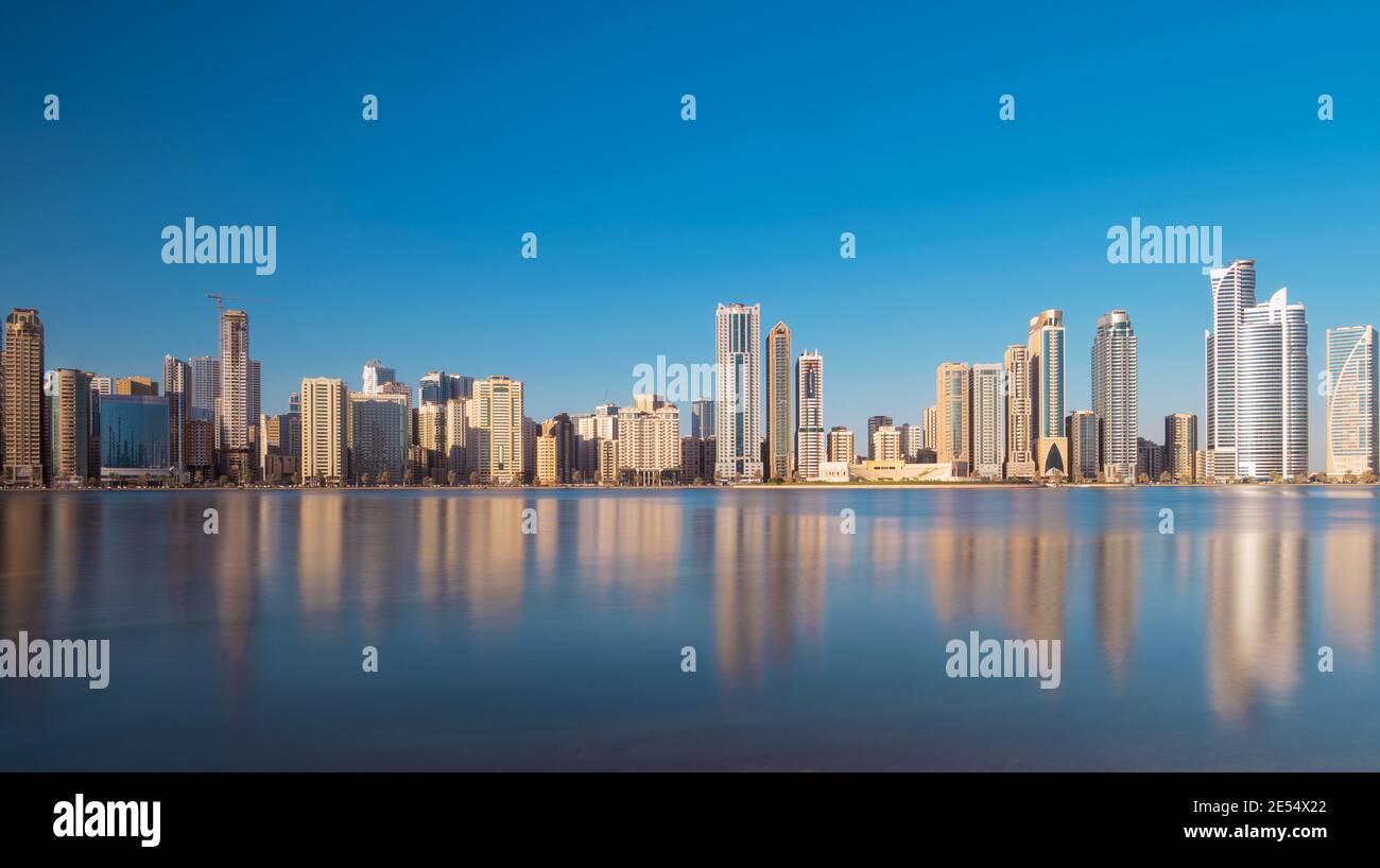 Sharjah, eau - 9 janvier 2021. Vue panaromique des gratte-ciel de sharjah montrant de magnifiques reflets dans l'eau capturés au lever du soleil tôt le matin. Banque D'Images