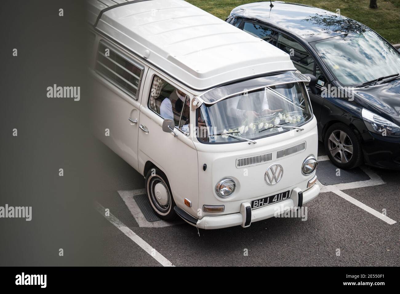VW Camper van réflexion dans le sol après la pluie eau blanche Écran refroidi classique Volkswagen mariage voiture crème acier roues rouge Image miroir Polo Golf Banque D'Images