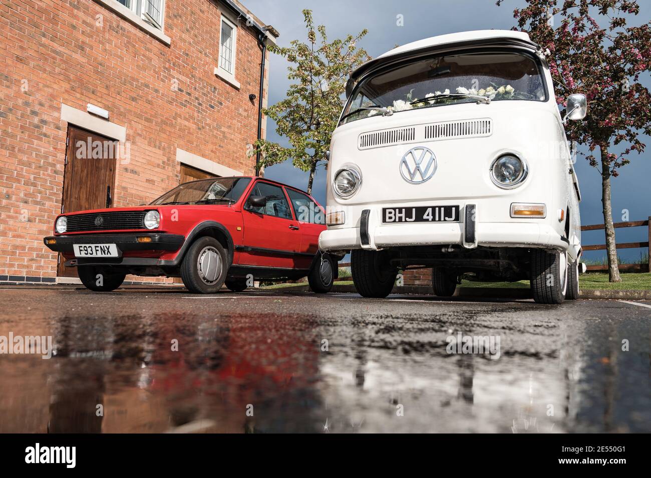 VW Camper van réflexion dans le sol après la pluie eau blanche Écran refroidi classique Volkswagen mariage voiture crème acier roues rouge Image miroir Polo Golf Banque D'Images
