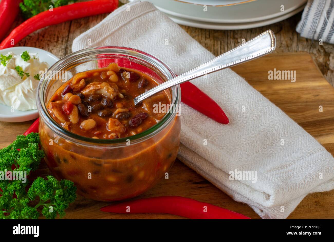 soupe de haricots frais et de viande de poulet bol en verre sur table en bois Banque D'Images