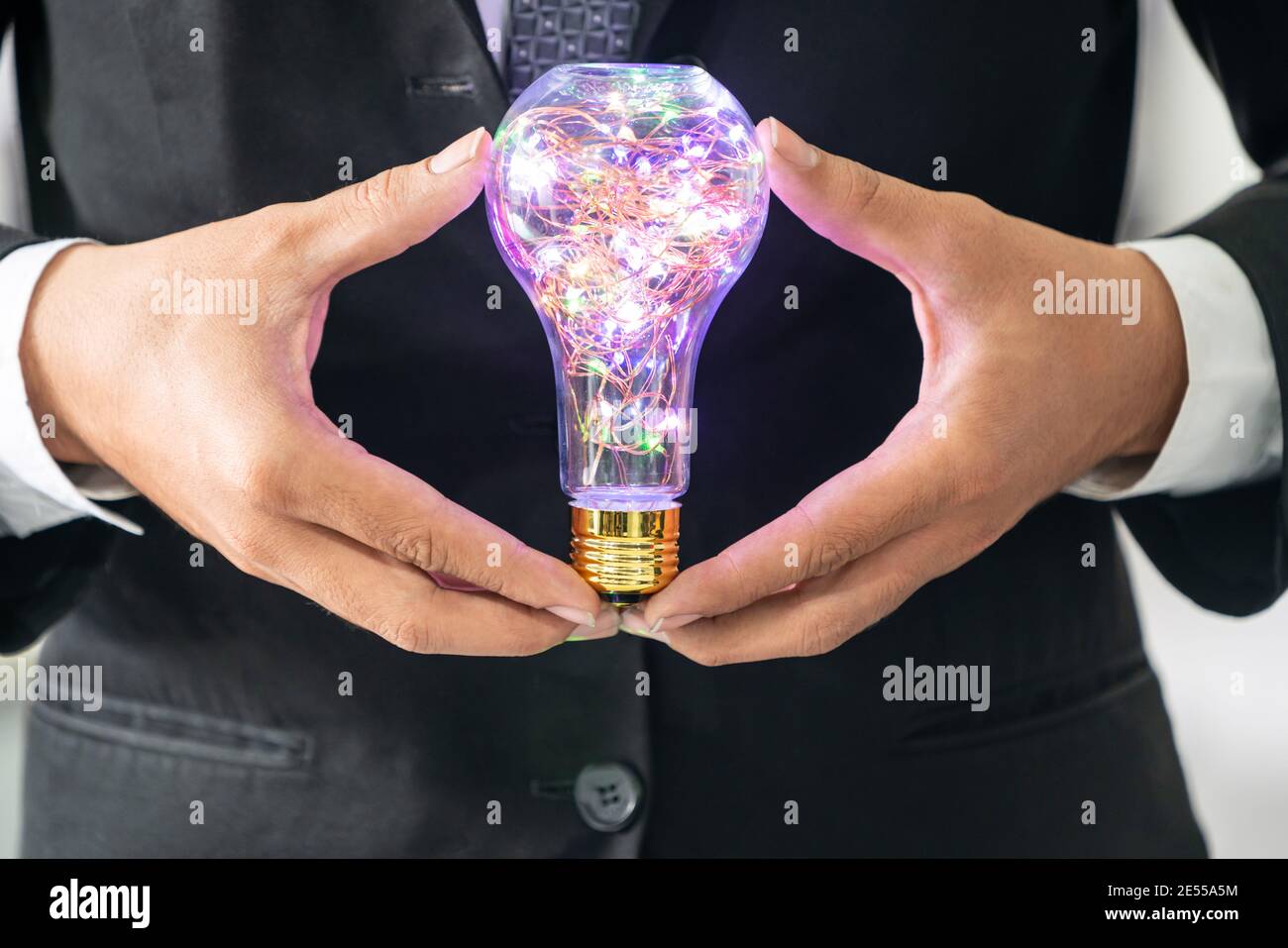 Businessman holding glowing ampoule dans les mains. Concept de créativité et d'idées. Banque D'Images