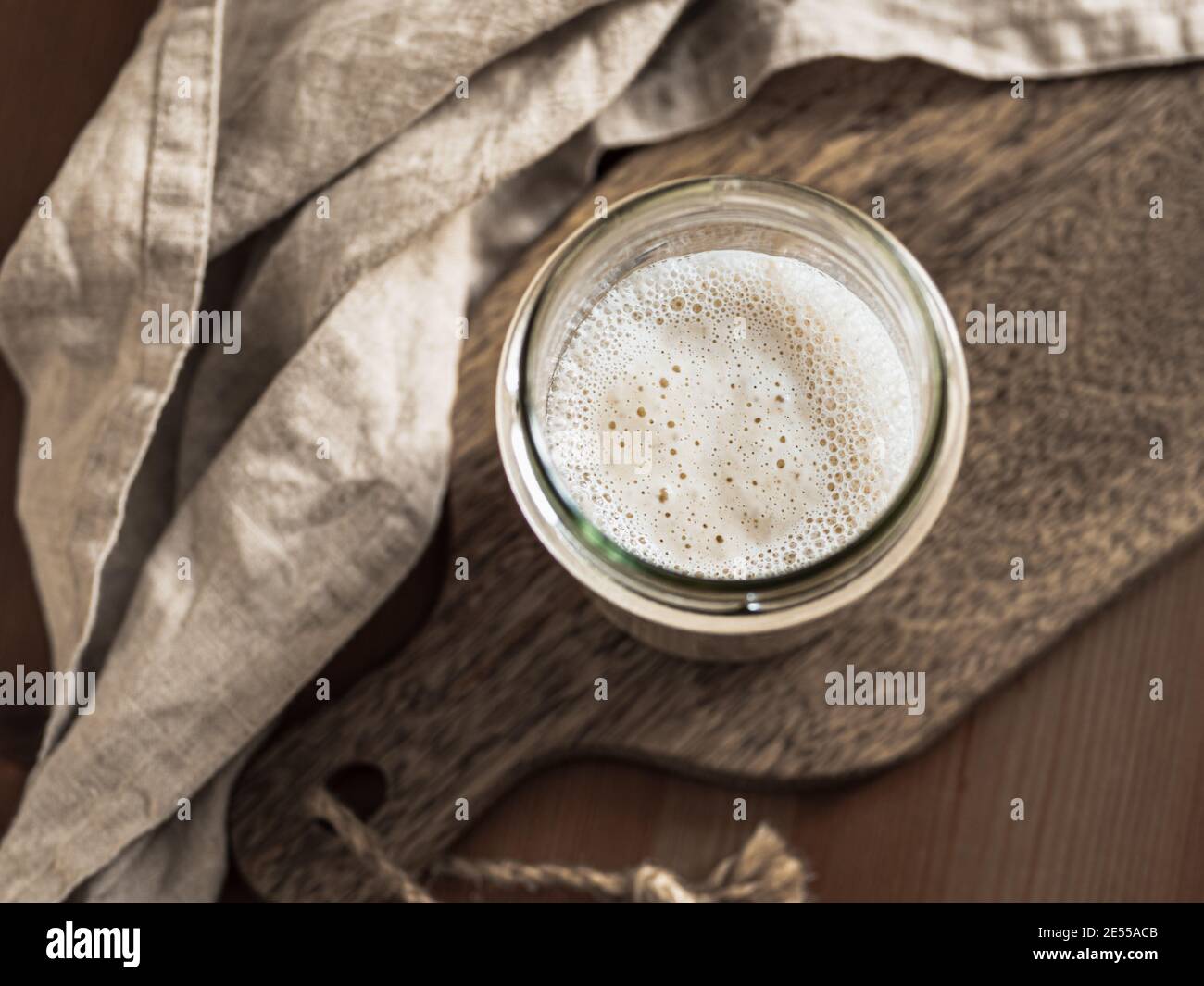 Démarreur de levain de blé. Vue de dessus du bol en verre avec démarreur à la pâte sur planche à découper en bois. Copier l'espace pour le texte ou la conception. Banque D'Images