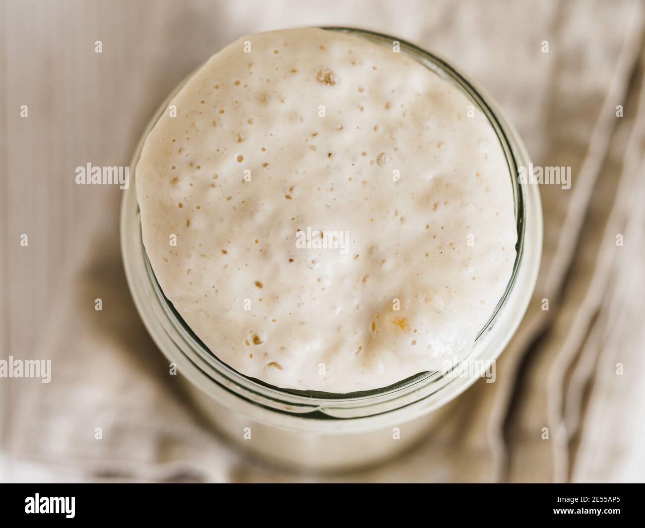 Démarreur de levain de blé. Vue de dessus du bol en verre avec démarreur de levain sur fond de bois blanc. Copier l'espace pour le texte ou la conception. Banque D'Images