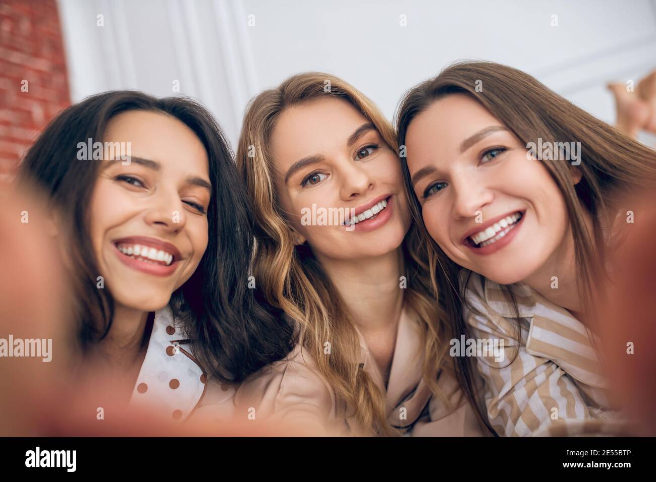 Trois filles faisant le selfie et regardant heureux Banque D'Images